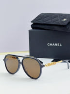 Chanel round sunglasses with dark frames and amber lenses, angled front view.