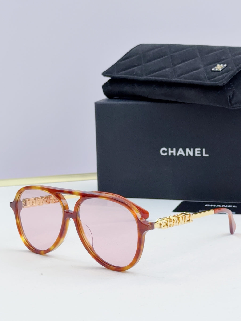 Chanel round sunglasses with tortoiseshell frames and light tan lenses, front view.
