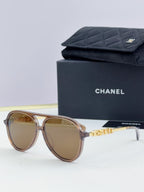 Chanel round sunglasses with tortoiseshell frames and brown lenses, front view.
