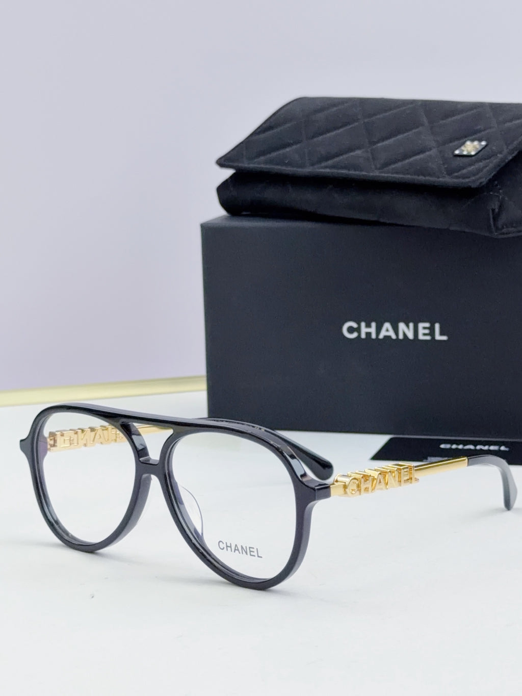 Chanel optical glasses with dark gray round frames and gold chain-like temples