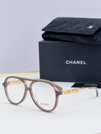 Chanel optical glasses with brown round frames and gold logo detailing on temples