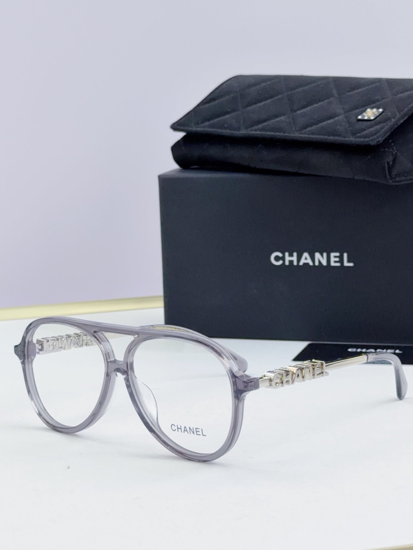 Chanel optical glasses with gray round frames and gold logo detailing on temples