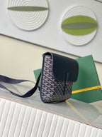 Navy crossbody bag with top flap, front monogram pattern, and shoulder strap