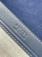 Close-up of navy leather trim with contrast stitching and embossed emblem
