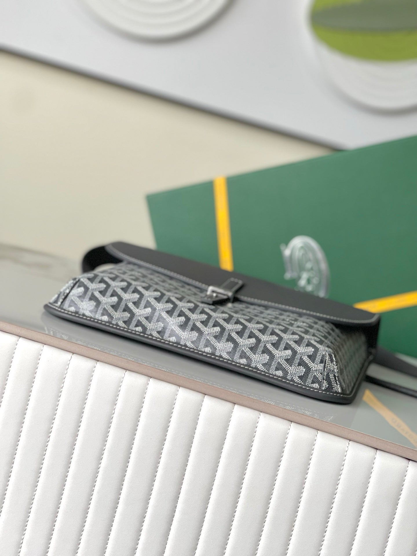 Goyard patterned clutch-style bag with gray top flap and strap