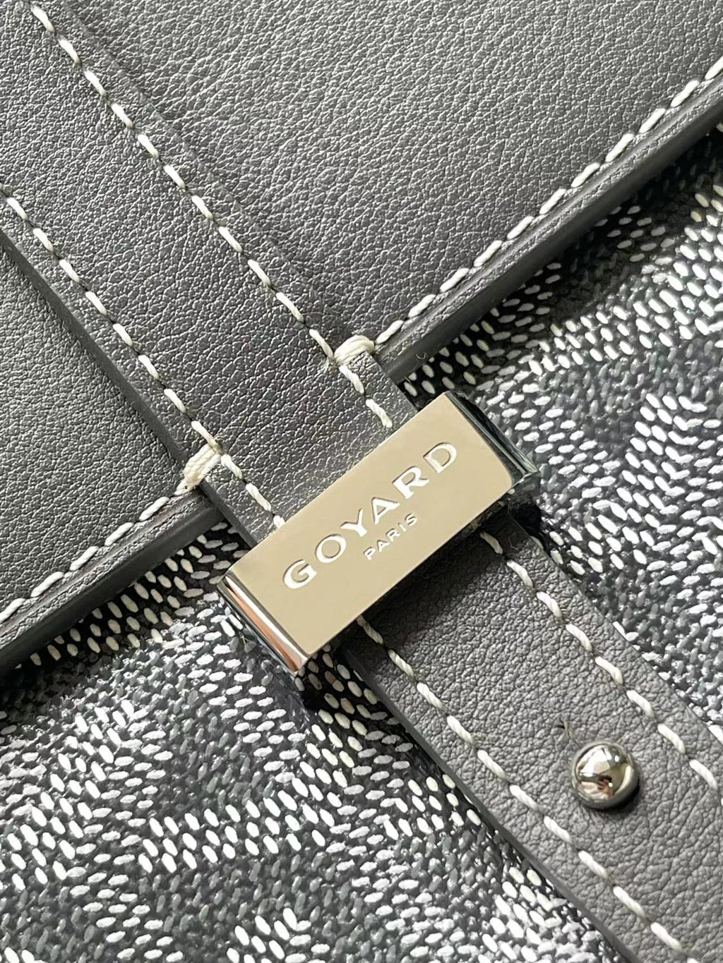 Goyard logo plaque on gray flap with stitched trim