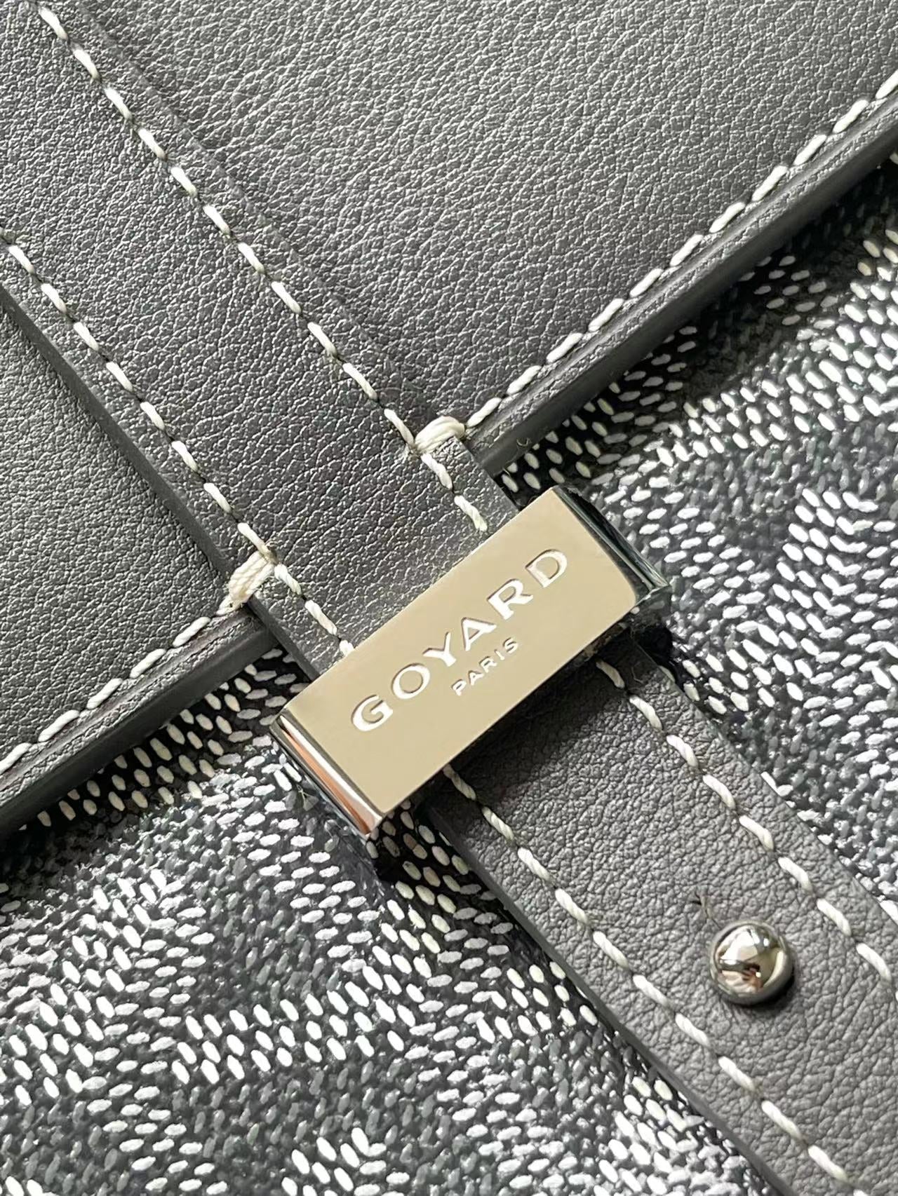 Goyard logo plaque on gray flap with stitched trim