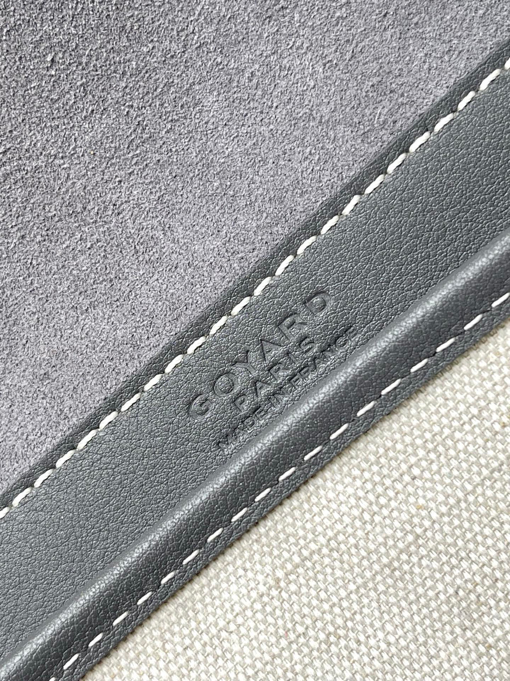 Goyard embossed logo on gray leather trim with contrast stitching