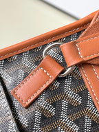 Patterned bag with tan leather handle loop and silver-ring strap attachment