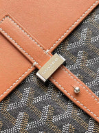Leather strap patch with GOYARD logo on patterned bag with tan stitching