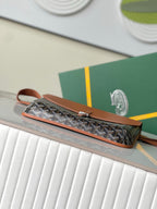 Long patterned clutch bag with tan zipper pull and wrist strap