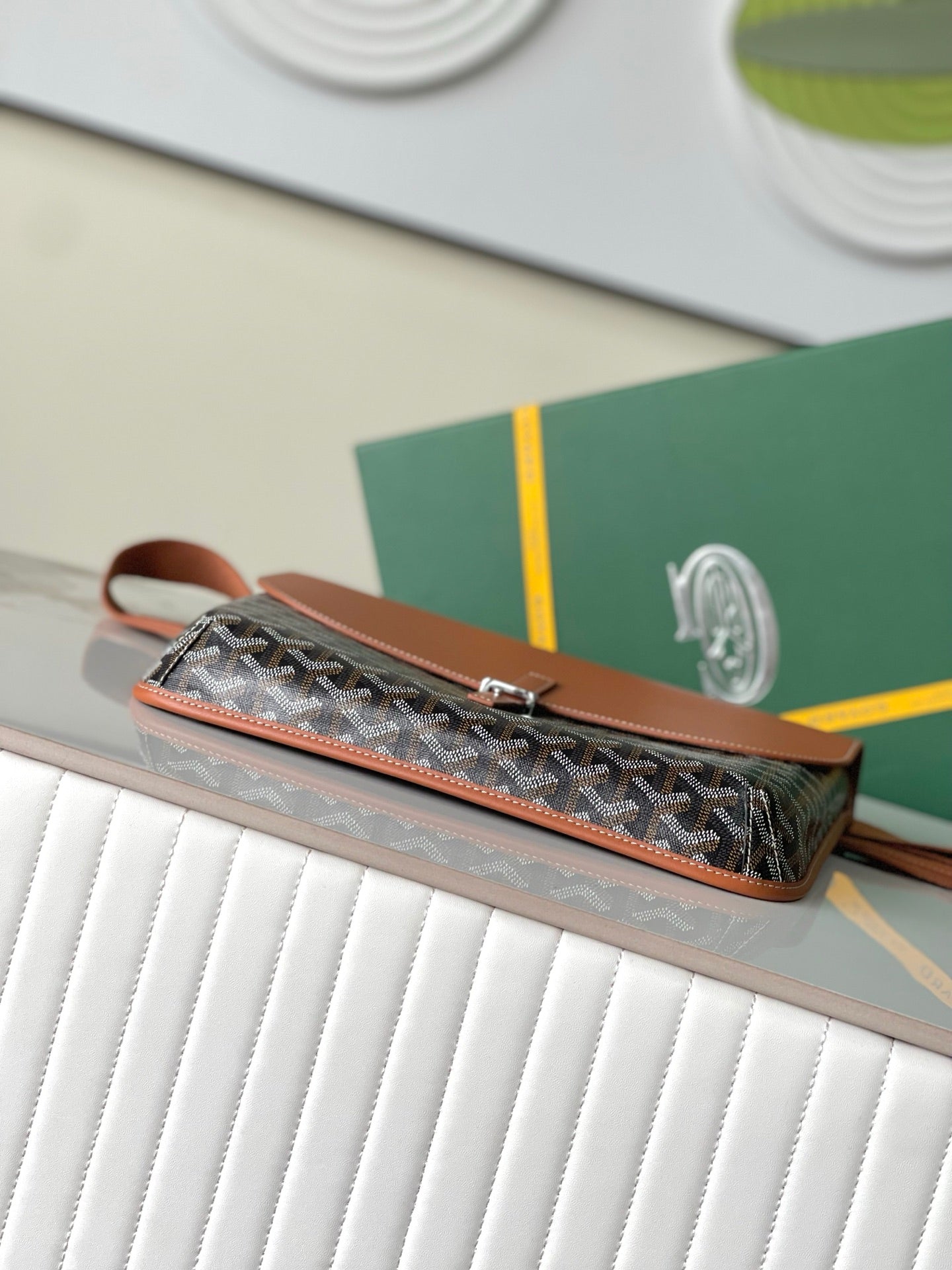 Long patterned clutch bag with tan zipper pull and wrist strap