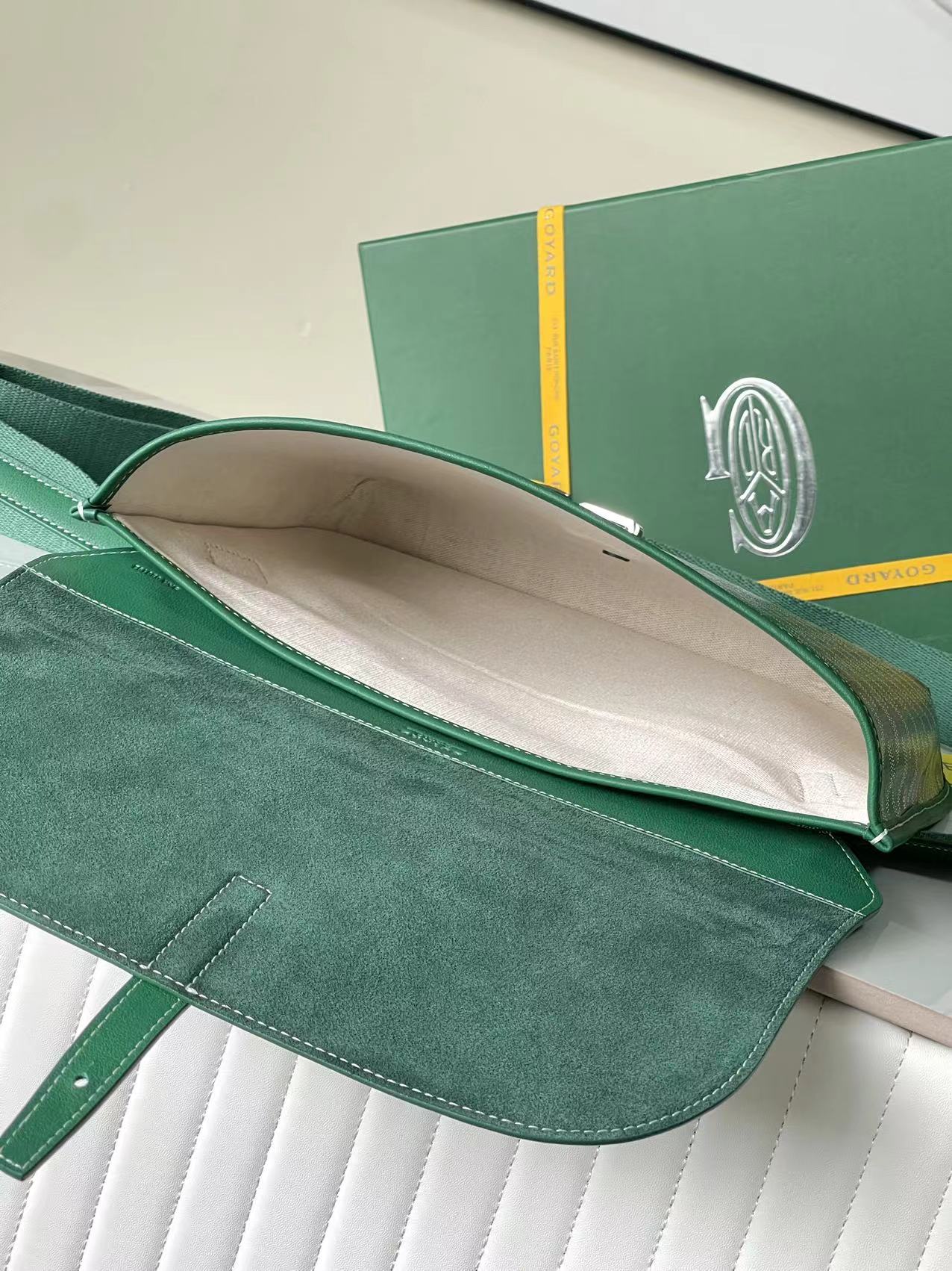 Goyard green monogram bag open with beige interior and wide flap