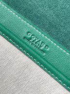 Green leather trim with white stitching and embossed Goyard text