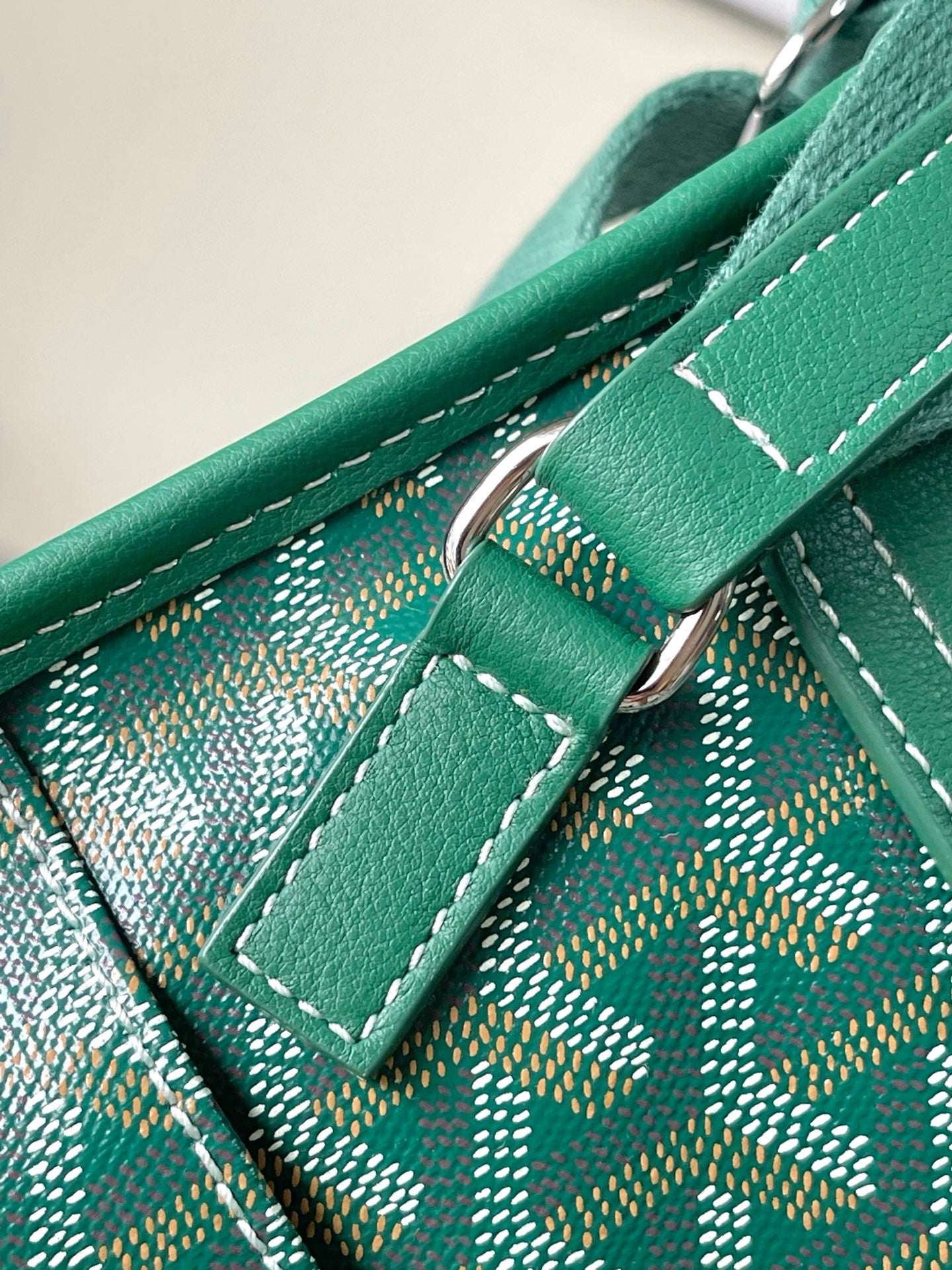 Green leather strap and ring hardware with stitched monogram panel