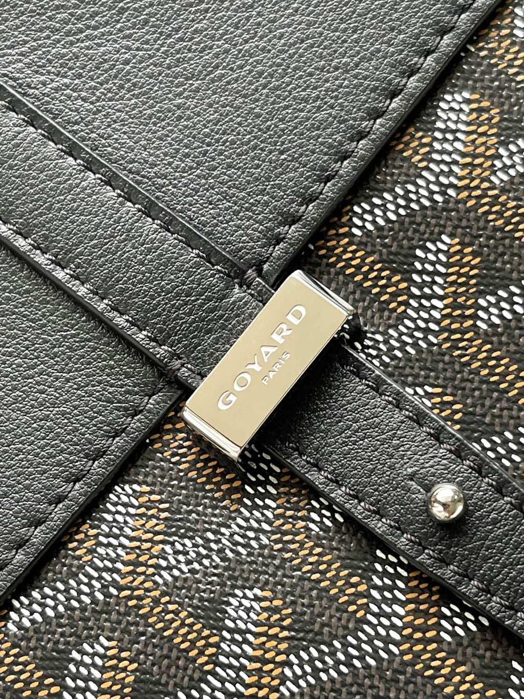 Goyard logo plaque on dark leather strap with patterned canvas