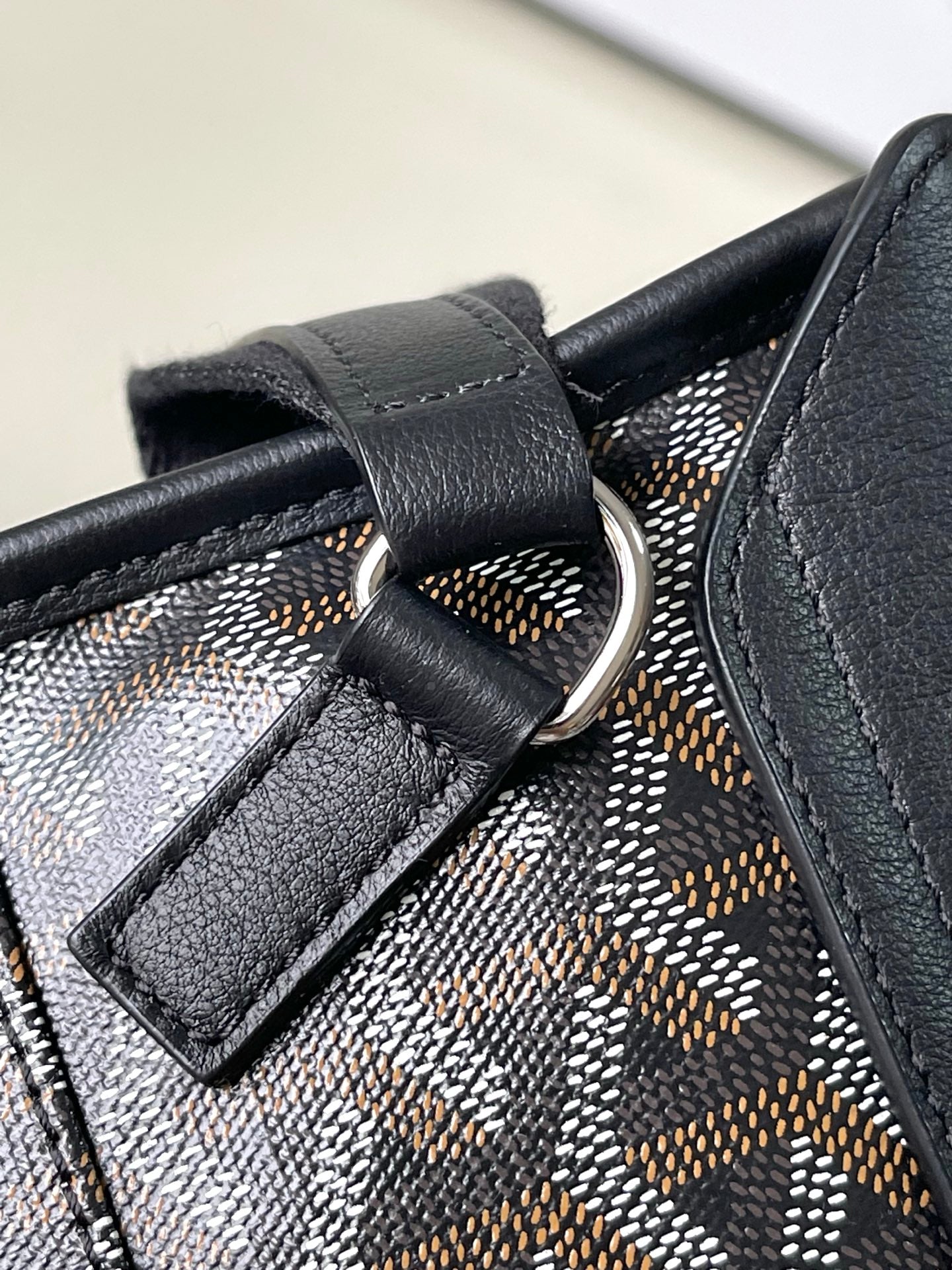 Goyard patterned canvas bag with dark leather loop and metal ring