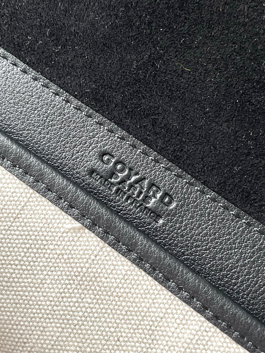 Goyard logo embossed on dark leather strap