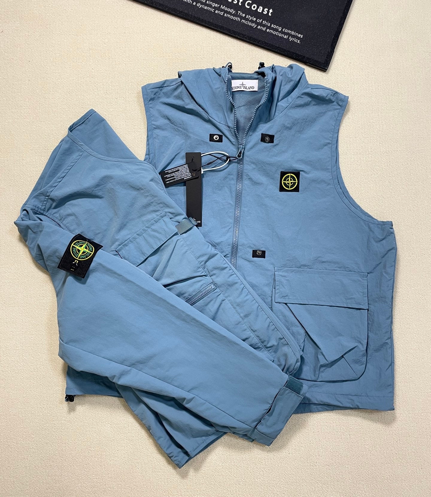 Light blue Stone Island hooded zip vest with front pockets and logo patch