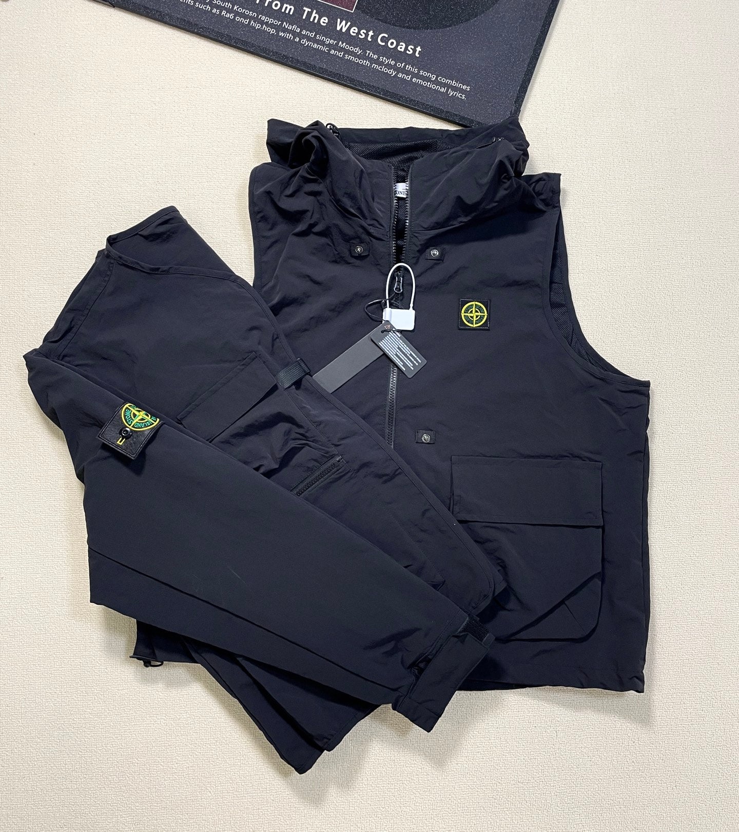 Dark navy Stone Island hooded zip vest with multiple pockets and logo patch