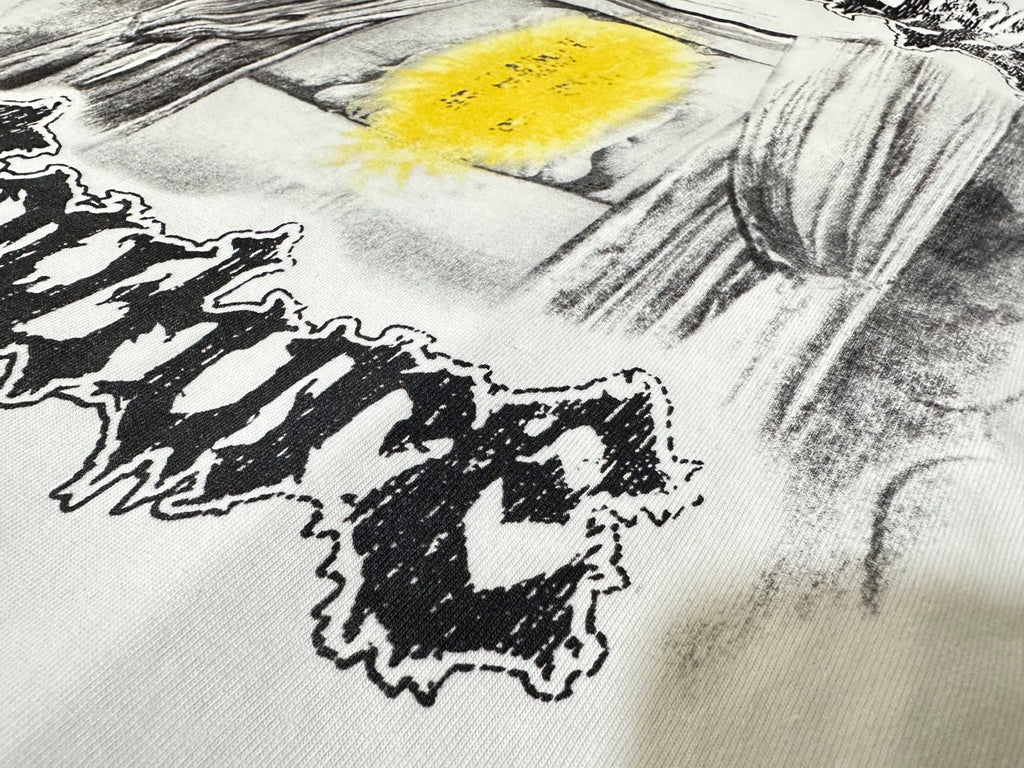 White T-shirt fabric close-up of black lettering and yellow paint splash print