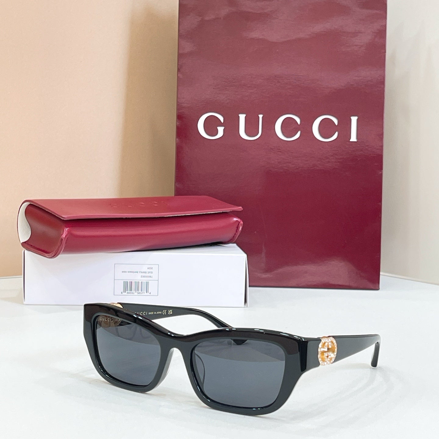 Black rectangular sunglasses with dark lenses and gold logo detail