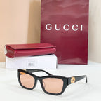 Black rectangular sunglasses with tan lenses and gold logo detail