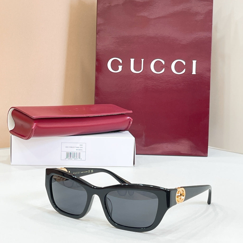 Black rectangular sunglasses with dark lenses and gold logo detail