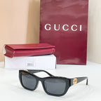 Black rectangular sunglasses with dark lenses and gold logo detail