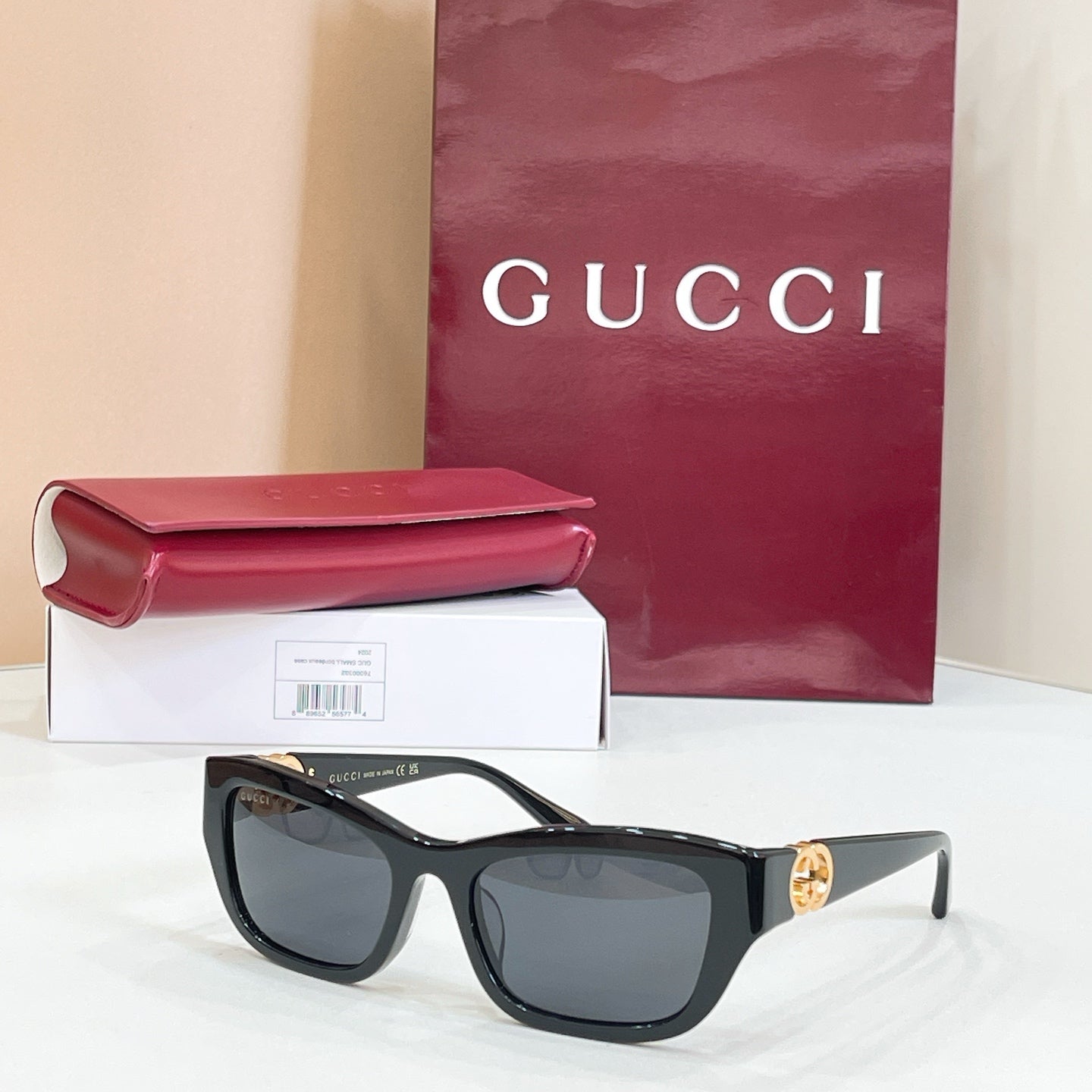 Black rectangular sunglasses with dark lenses and gold logo detail