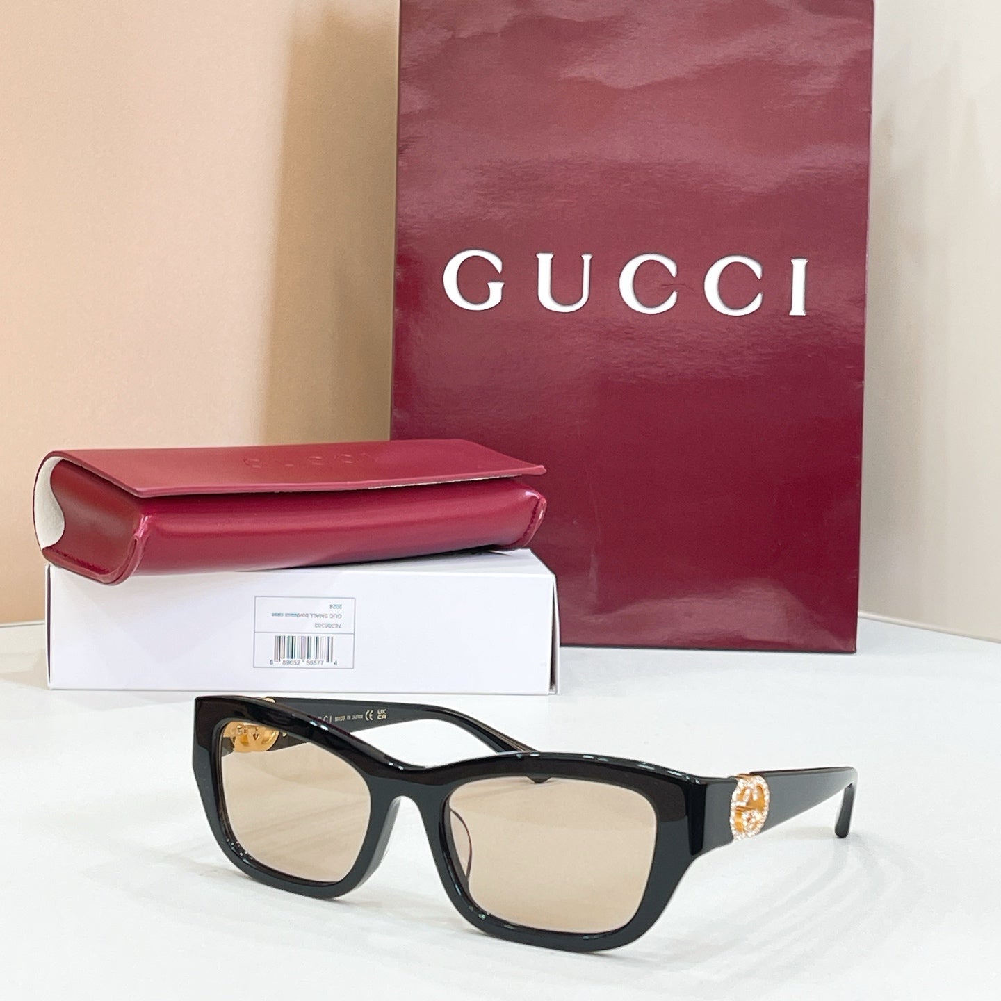 Black rectangular sunglasses with light lenses and gold logo detail