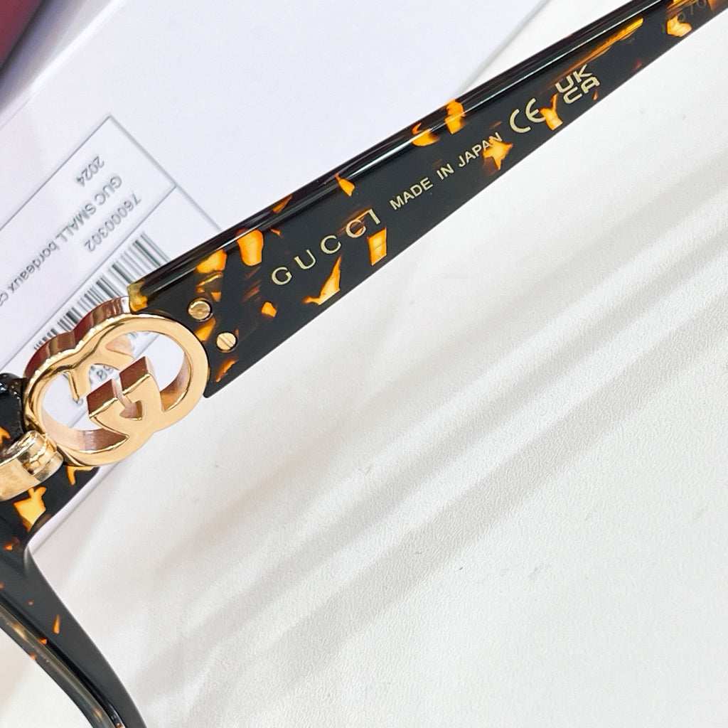 Gucci eyeglasses temple, black with gold GG emblem and text