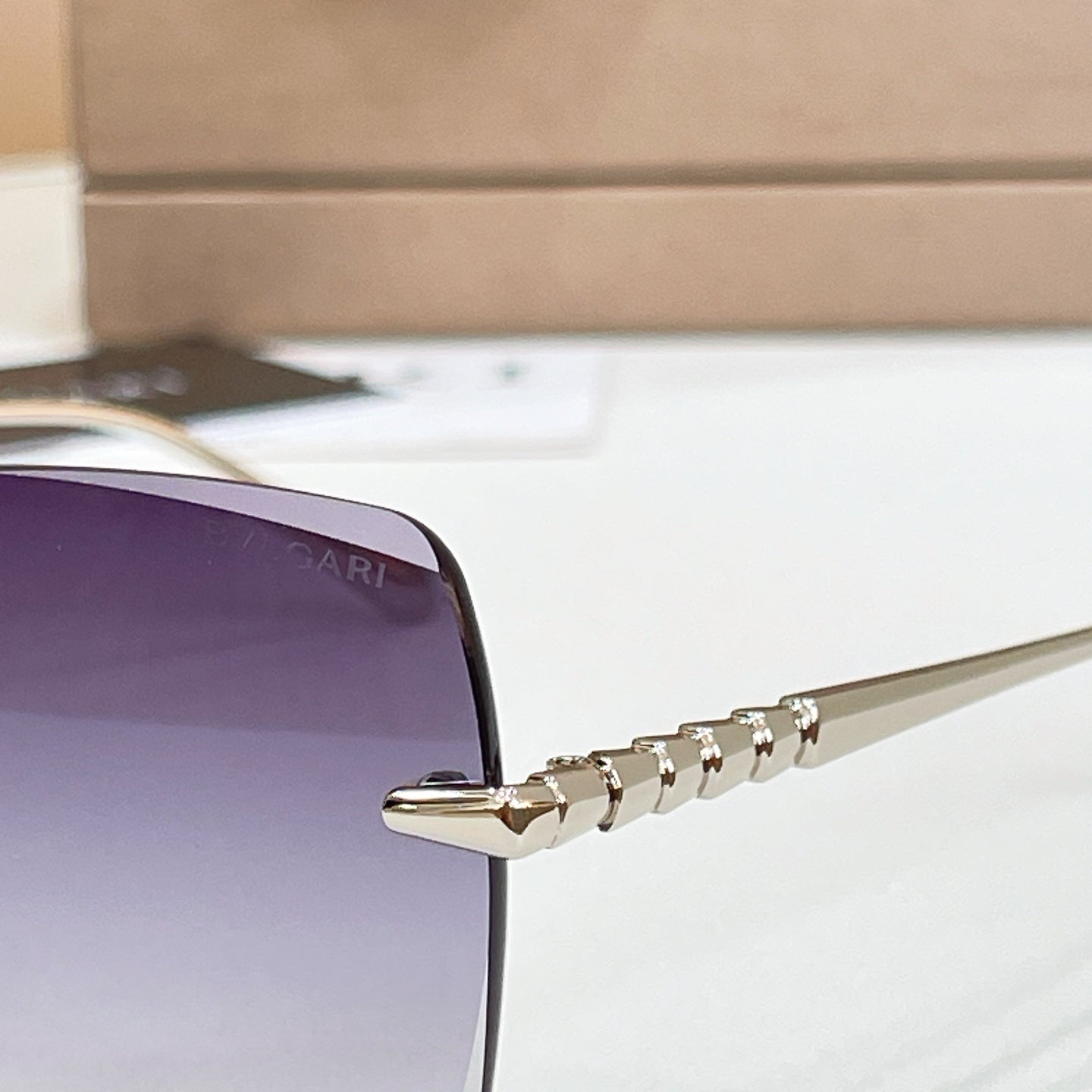 Bvlgari sunglass temple with gold-tone engraved detail and metal hinge