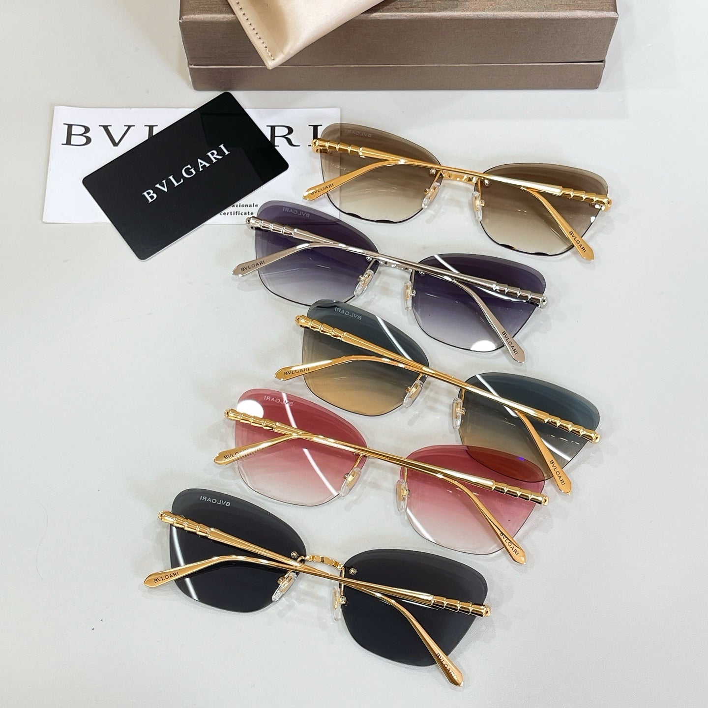 Assorted sunglasses with gold-tone frames and mixed dark, purple, and red lens tints
