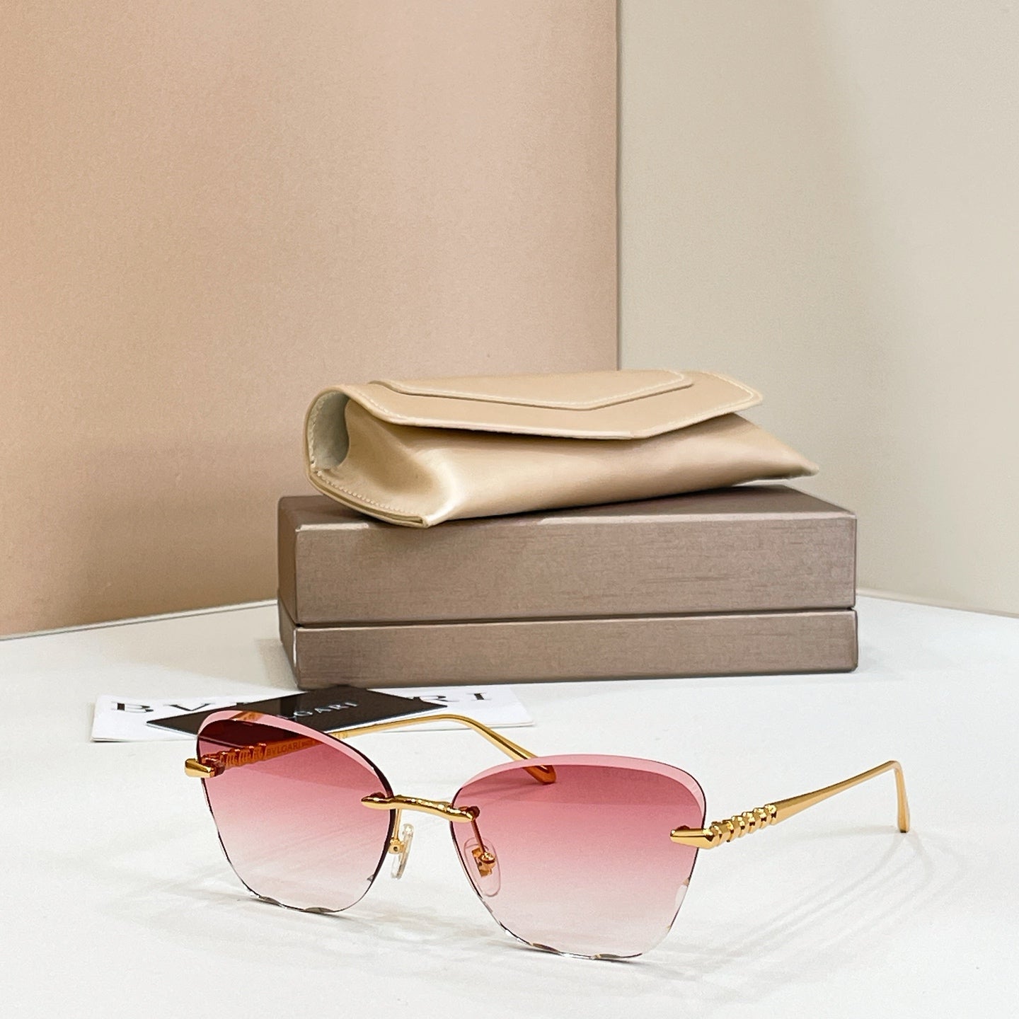Gold-tone sunglasses with pink tinted lenses and thin rectangular frames