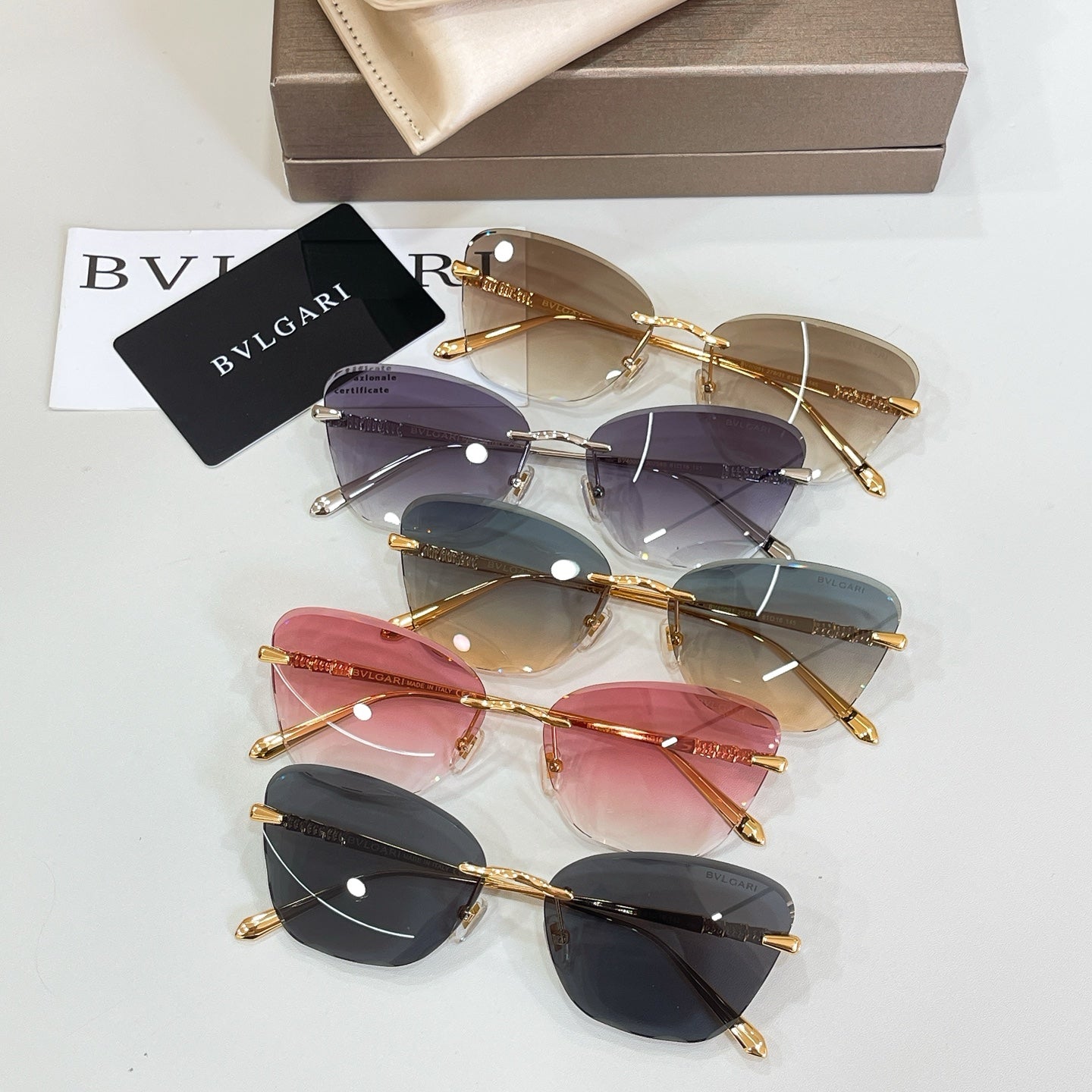 Assorted sunglasses with gold-tone frames and mixed tinted lenses in a stack