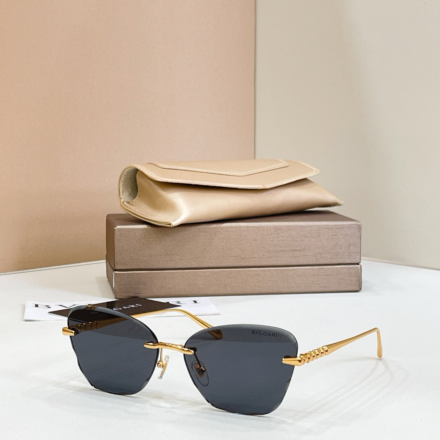 Gold-tone sunglasses with dark blue tinted lenses and thin rectangular frames