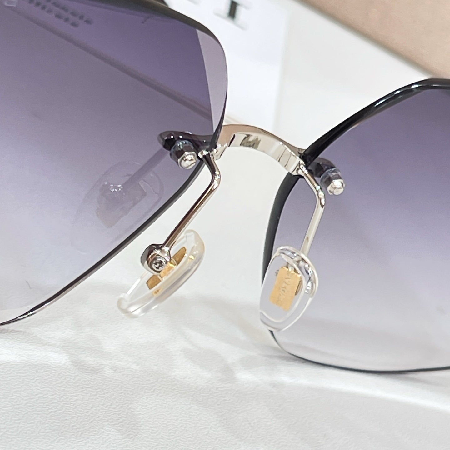Bvlgari purple-tinted sunglasses close-up of gold-tone frame and bridge