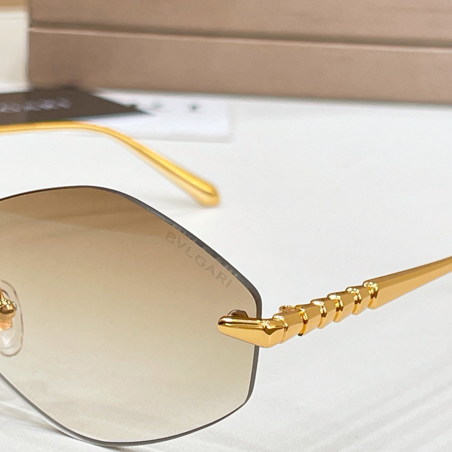Bvlgari sunglasses close-up: gold temples with blue tinted lens