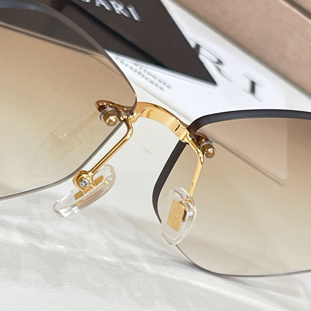 Bvlgari sunglasses close-up: gold frame and dark tinted lens