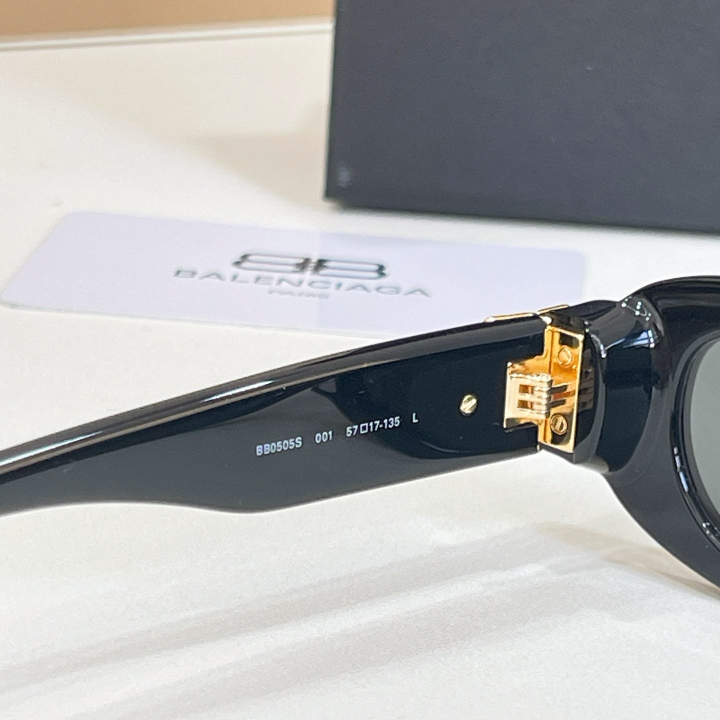 Balenciaga black sunglasses side arm with gold-tone hinge and engraved markings