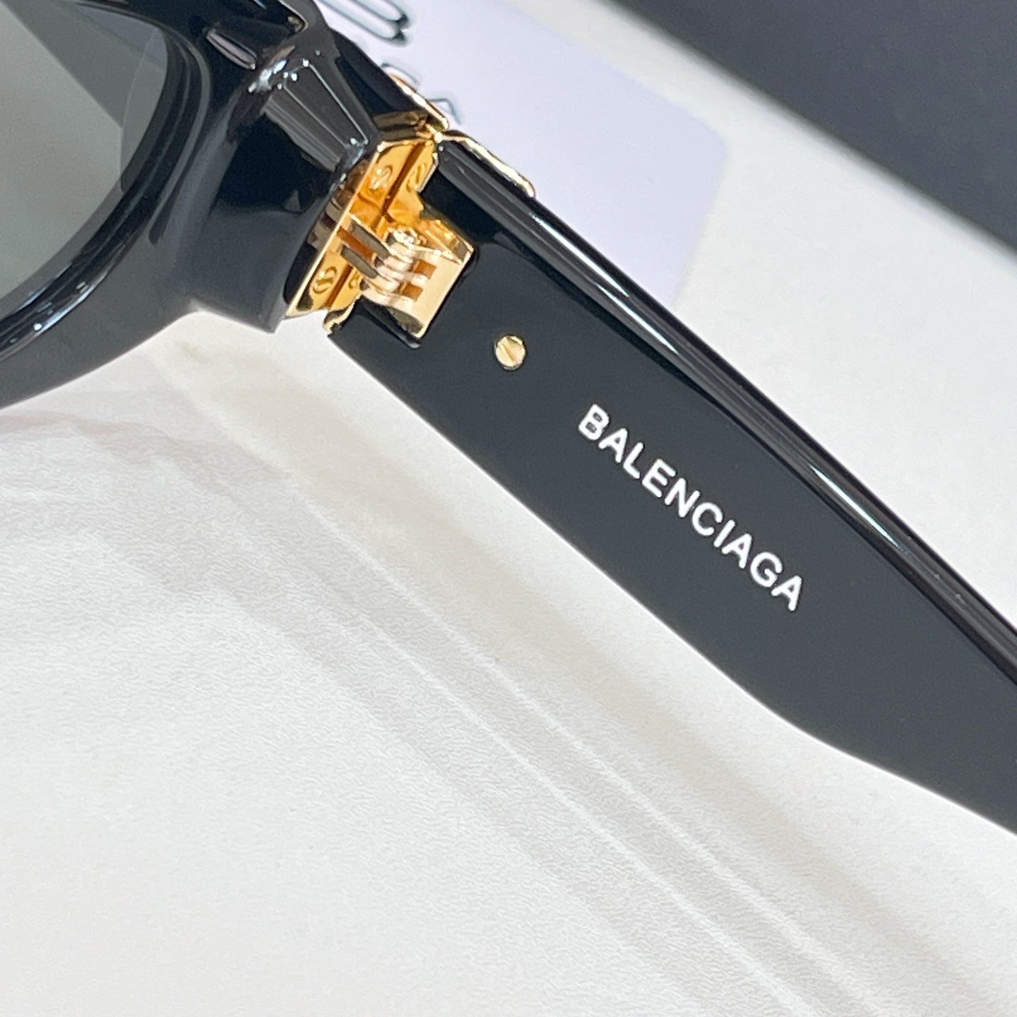 Balenciaga black sunglasses temple with BALENCIAGA text and gold-tone hinge