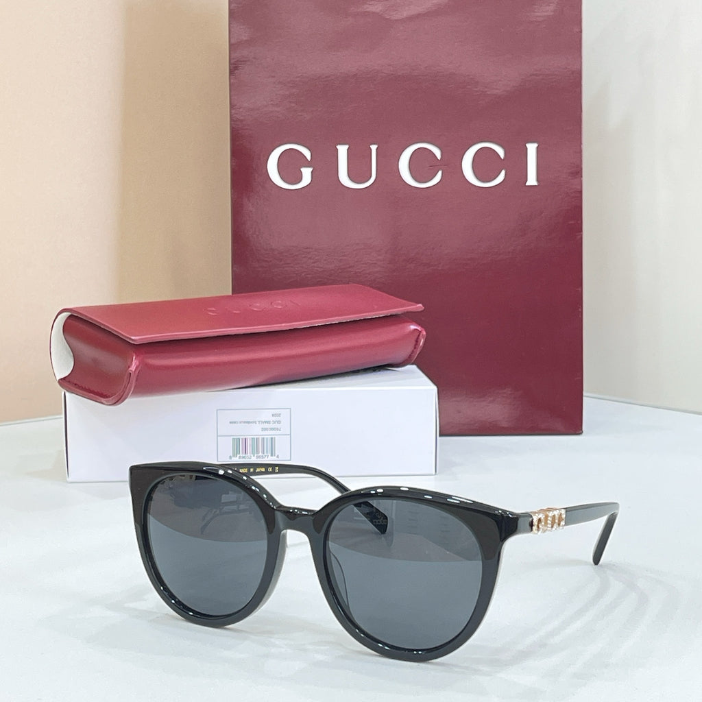 Gucci sunglasses with black cat-eye frames and dark gray lenses