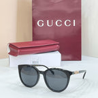 Gucci sunglasses with black cat-eye frames and dark gray lenses