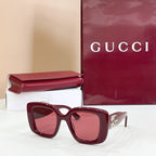 Gucci sunglasses with burgundy frames and pink-tinted lenses, gold GG logo temple.