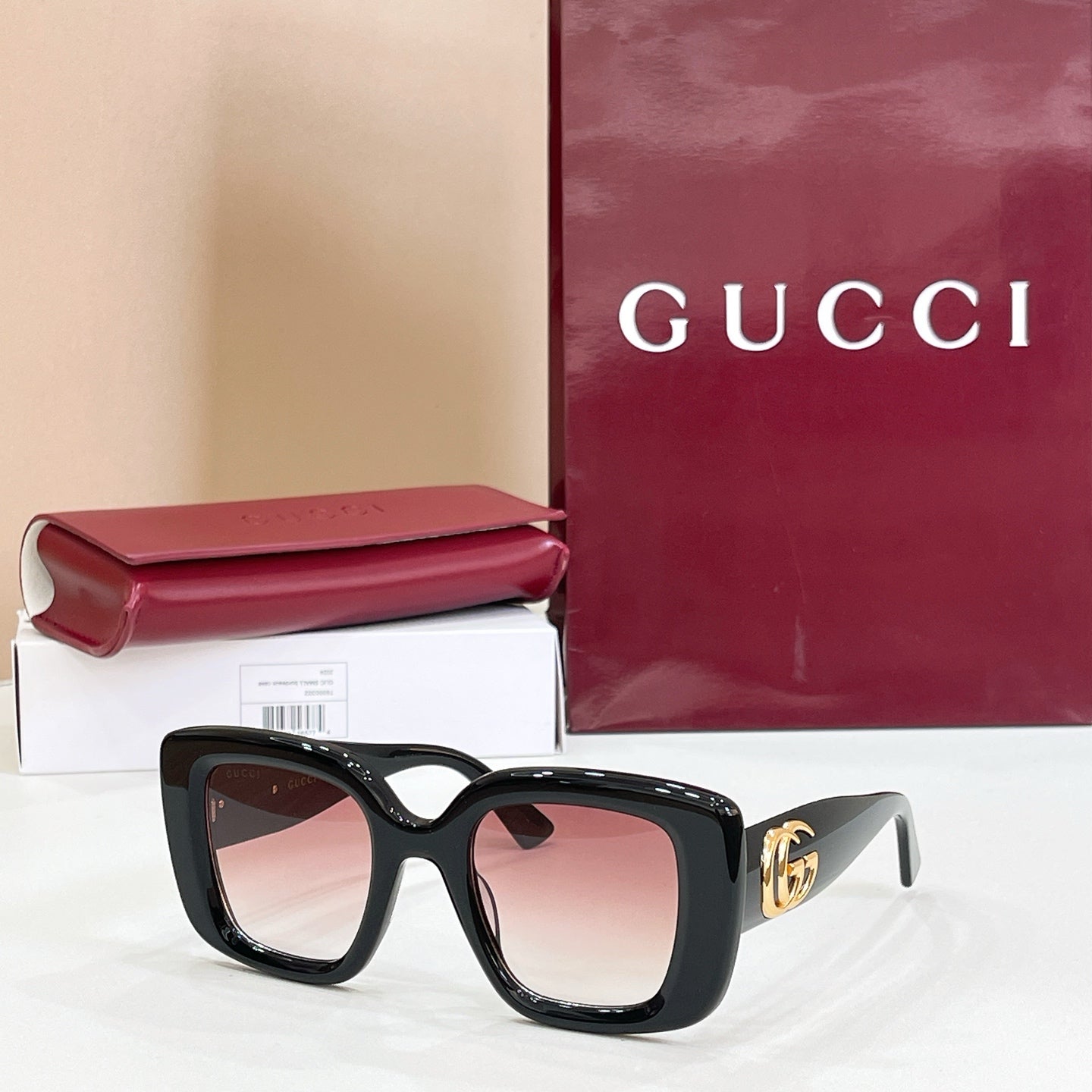 Gucci sunglasses with dark frames and tinted lenses, gold GG logo on temple.
