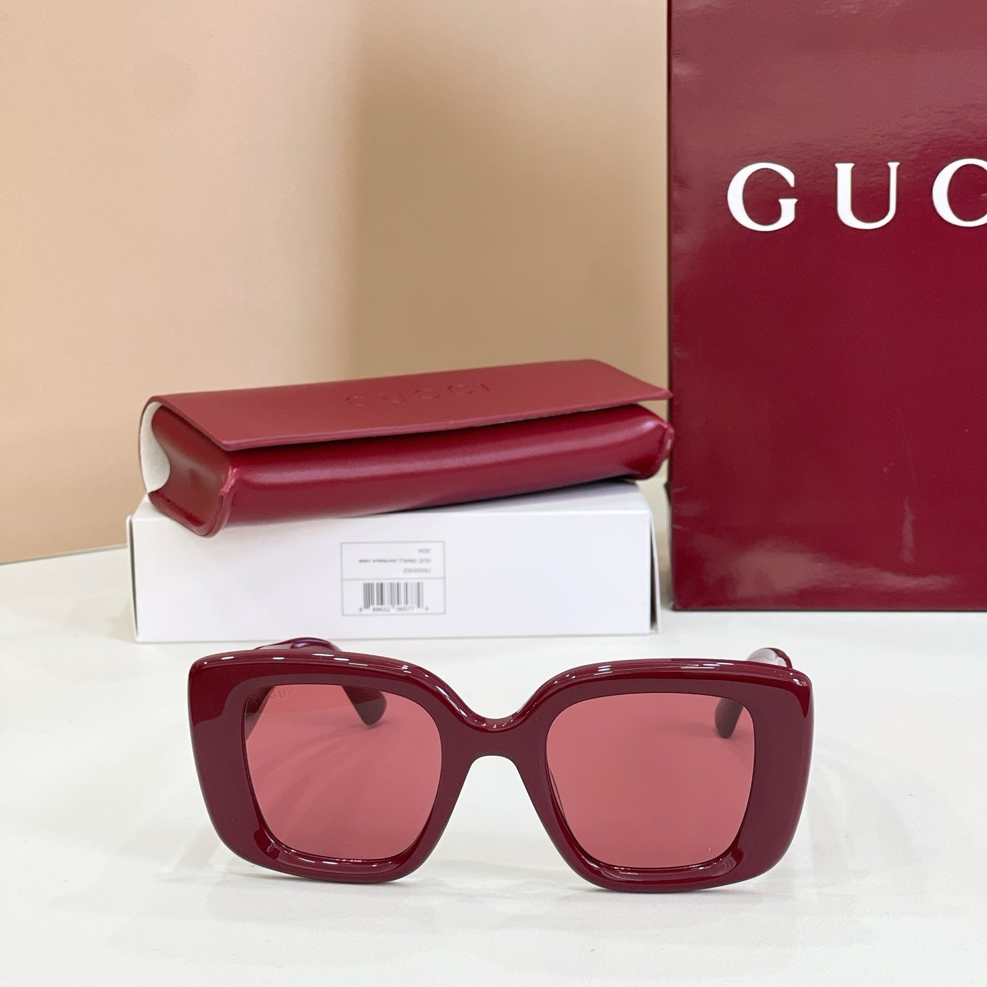 Burgundy oversized sunglasses with tinted lenses, on box and case