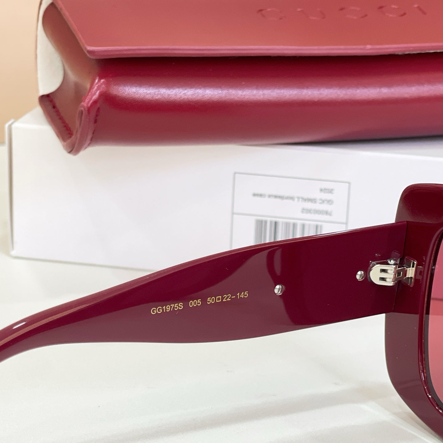 Burgundy sunglass arm with 'GG1975' and measurements printed