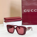 Burgundy sunglasses with tinted lenses and small gold-tone logo, with case
