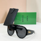 Sunglasses with black frames and dark lenses, plus black textured case